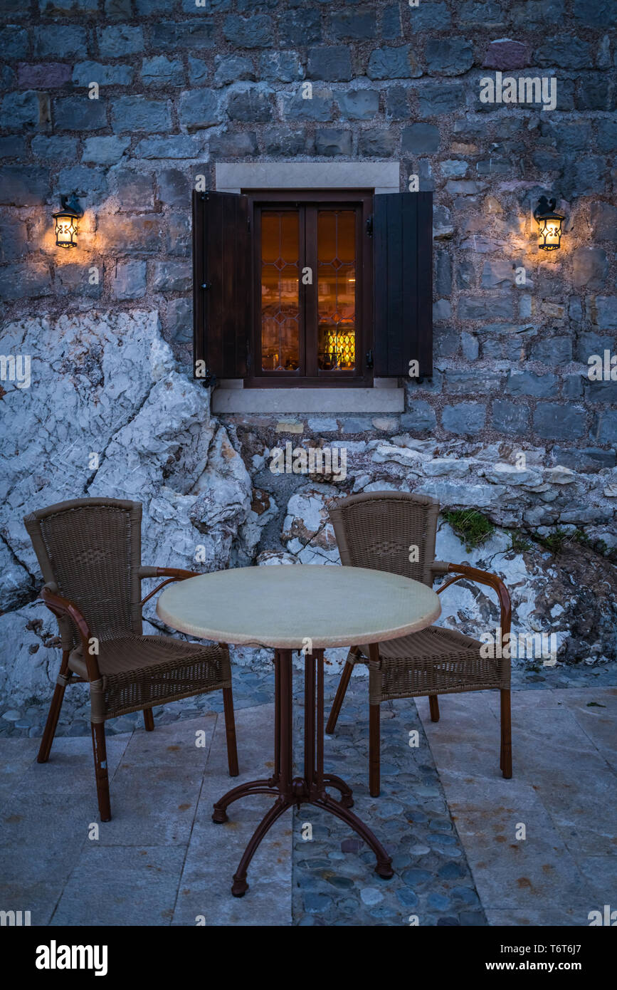 Empty table and wicker chairs outside cafe Stock Photo