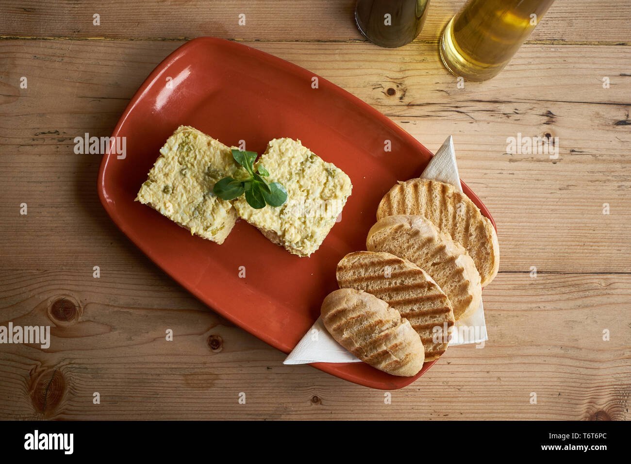 Olivieh Salad on a red plate and wooden table Stock Photo