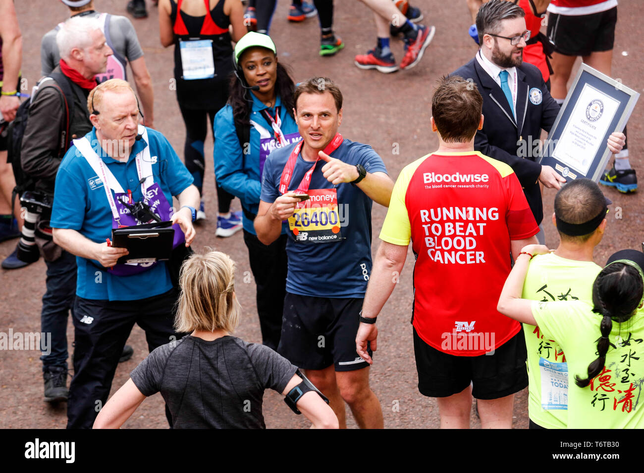 London, England – April 28, 2019: Paul William, MP presents his medal after crossing the finish line during the Virgin Money London Marathon. Stock Photo
