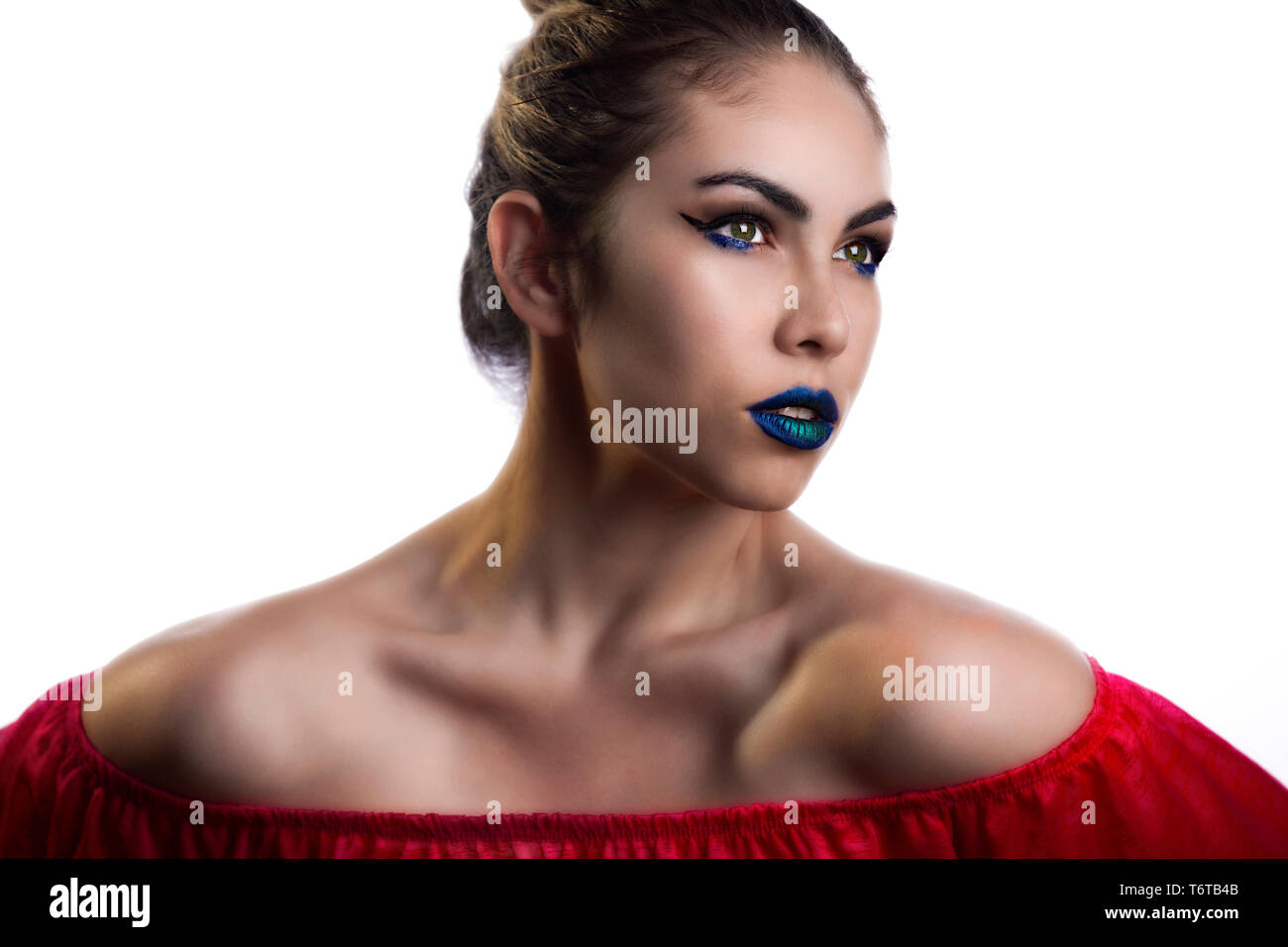 a Hispanic female model wearing vibrant neon blue lipstick and red dress.  she has big green eyes and wears a bluish green liner Stock Photo - Alamy