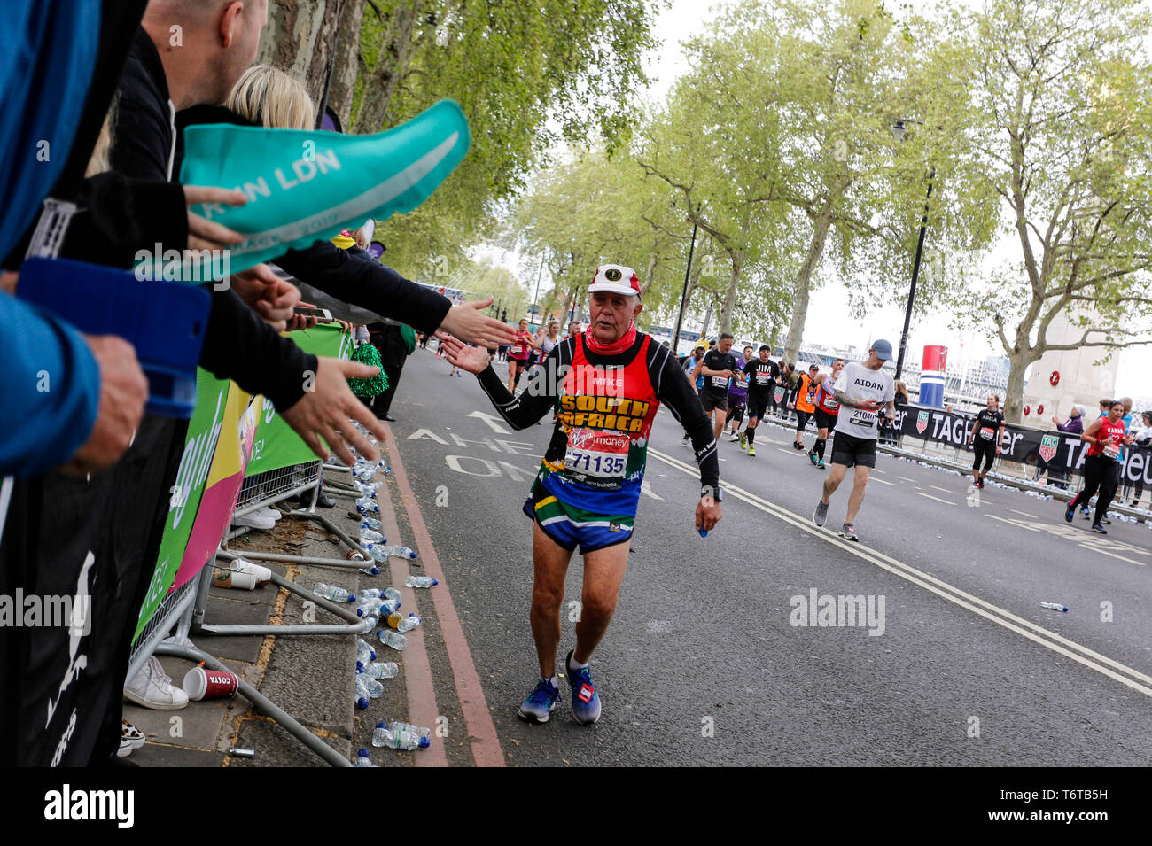 London, England – April 28, 2019: A man give high fives on his final mile of the Virgin Money London Marathon. Stock Photo
