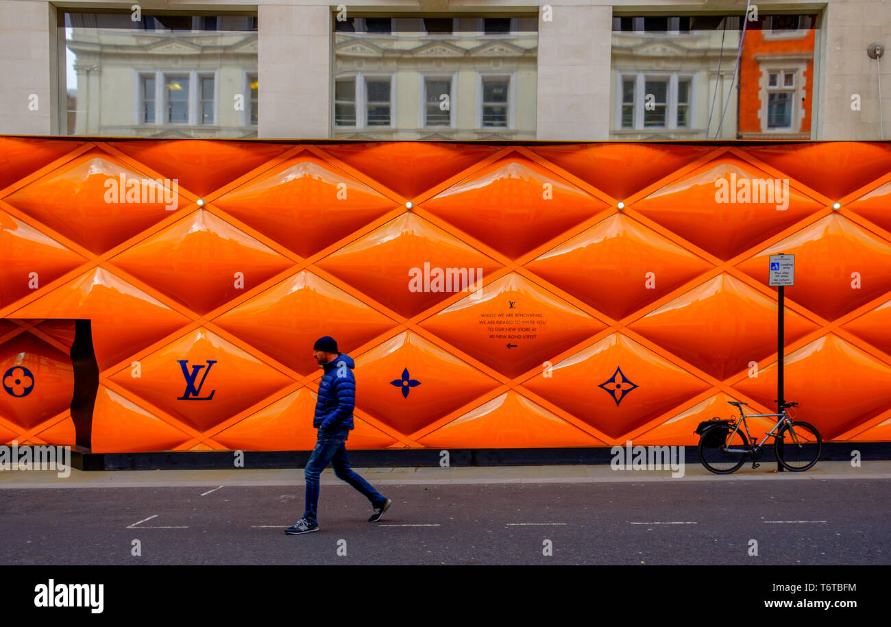 UK, March 2019, passing by building site fence panel for a Louis Vuitton shop in the area Stock Photo - Alamy