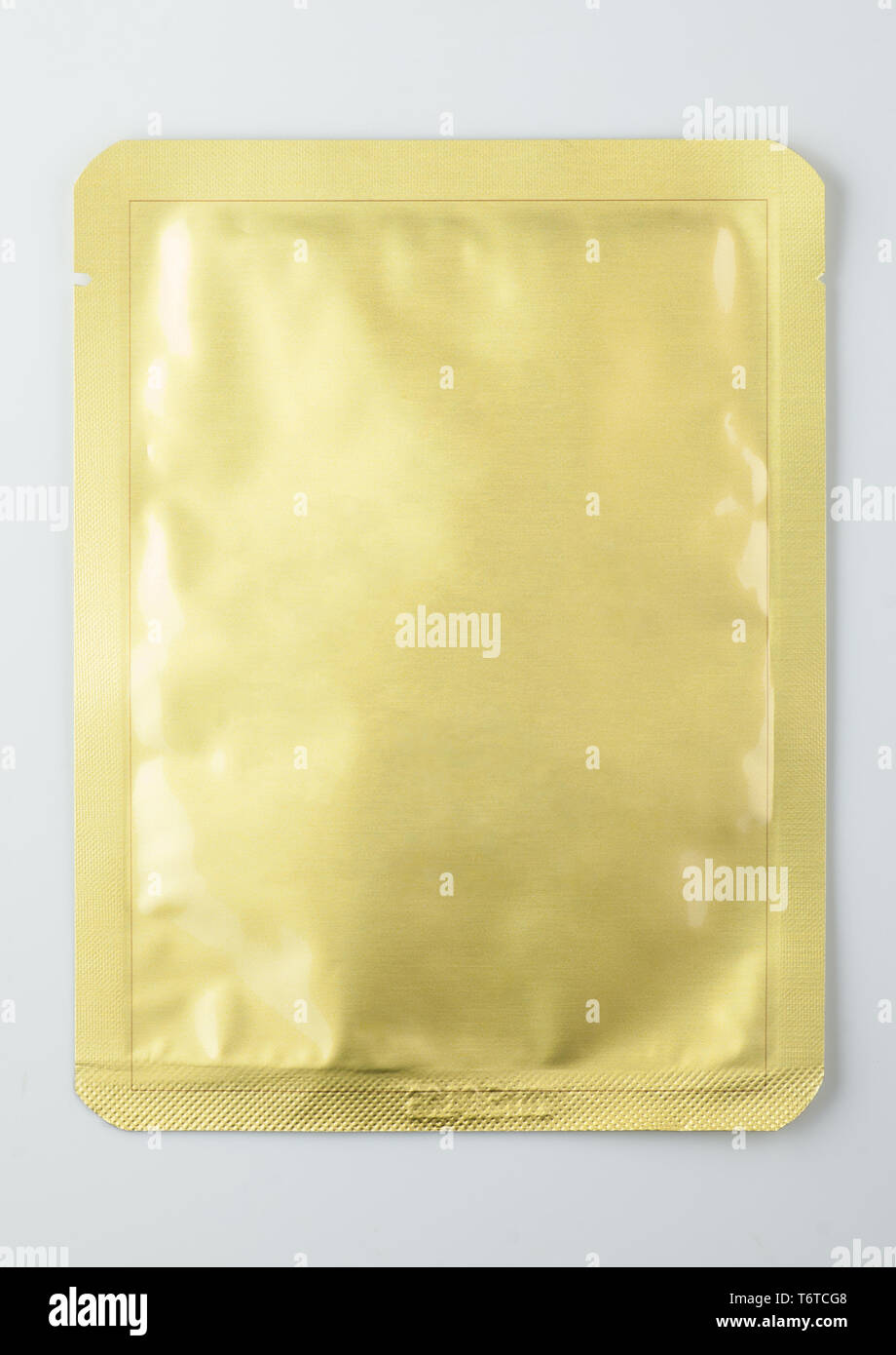 gold sealed cosmetic sachet, isolated on white background Stock Photo