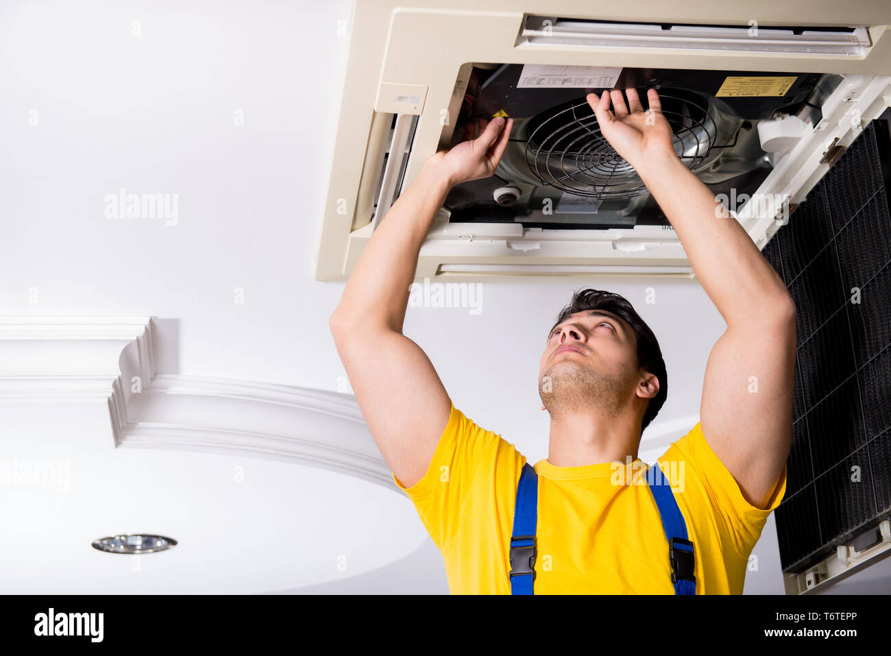 Repairman Repairing Ceiling Air Conditioning Unit Stock