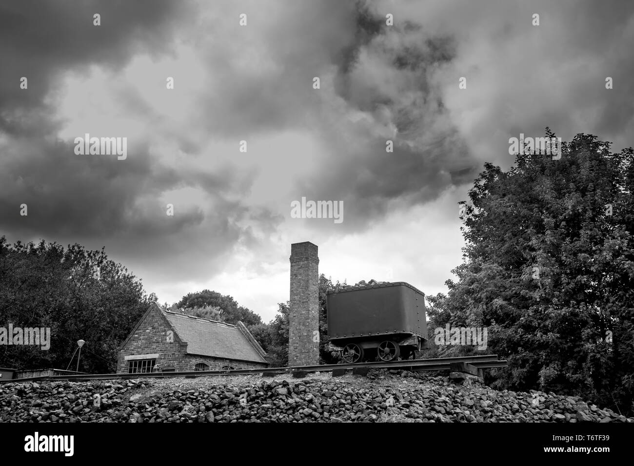 Moody, atmospheric, black and white, landscape photograph of dark clouds over coal mining colliery, Black Country Living Museum, Dudley, UK. Stock Photo