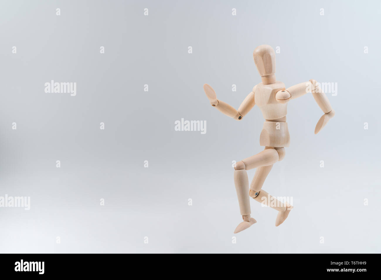 Wooden dummy proudly presents some invisible thing, isolated on white background, copy space for your object or text Stock Photo