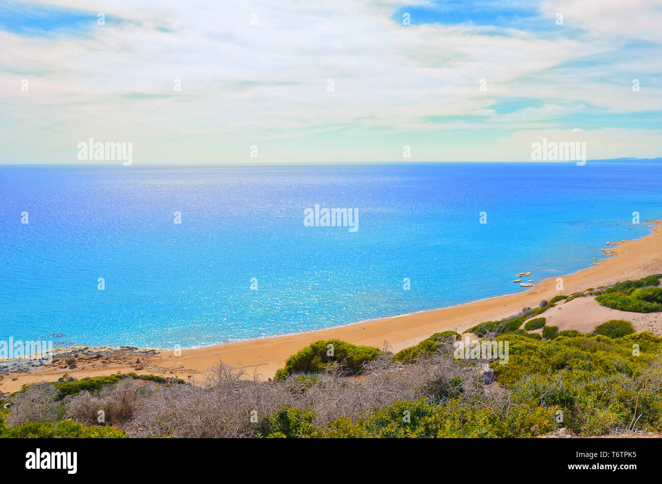 Beautiful empty beach in Turkish Northern Cyprus taken against the sun. The remote place is Golden Beach in Karpas Peninsula. Amazing destination for summer vacation without many tourists. Stock Photo