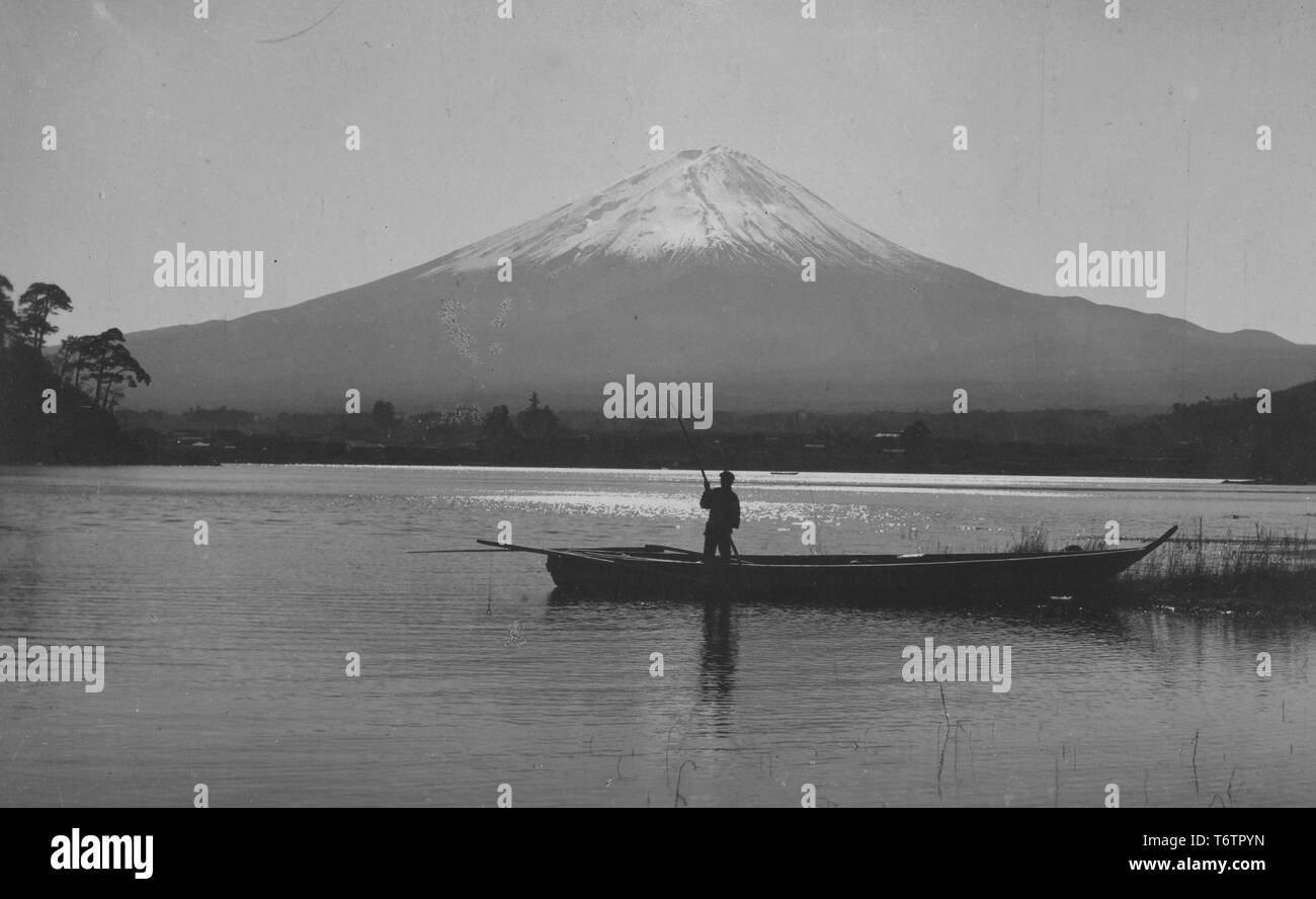 Photograph of the fisherman rowing the boat on a lake near Mount Fuji, Japan, 1920. From the New York Public Library. () Stock Photo
