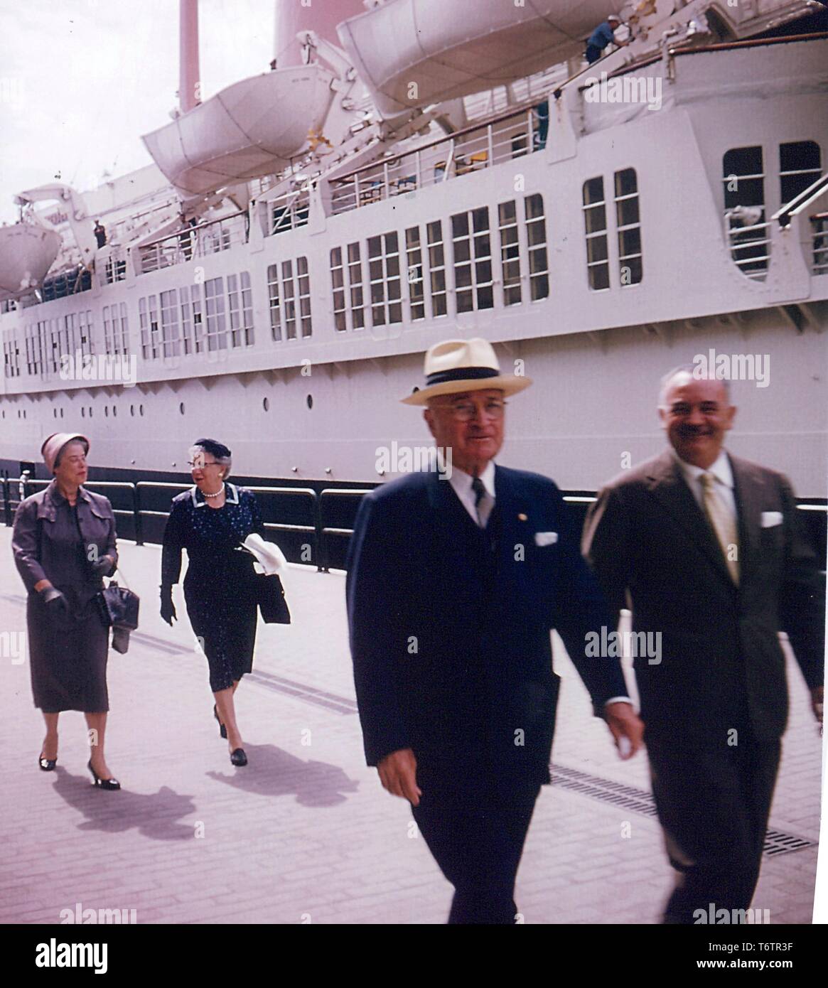 Former President Harry S. Truman, Bess Truman (first lady to President Truman), Mrs. Sam Rosenman, and an unidentified man walking on a pier with a boat in the background at Naples, Florida, June, 1958. Image courtesy National Archives. () Stock Photo
