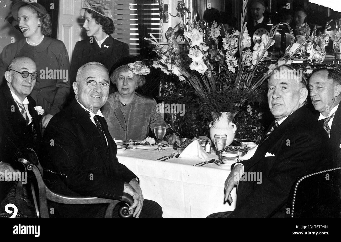 American President Harry Truman and Vice President Alben Barkley, both seated, turn toward the camera during an inauguration lunch, with Bess Truman, Margaret Truman and Marian Barkley Truitt at background left, Washington, DC, January 20, 1949. Image courtesy National Archives. () Stock Photo