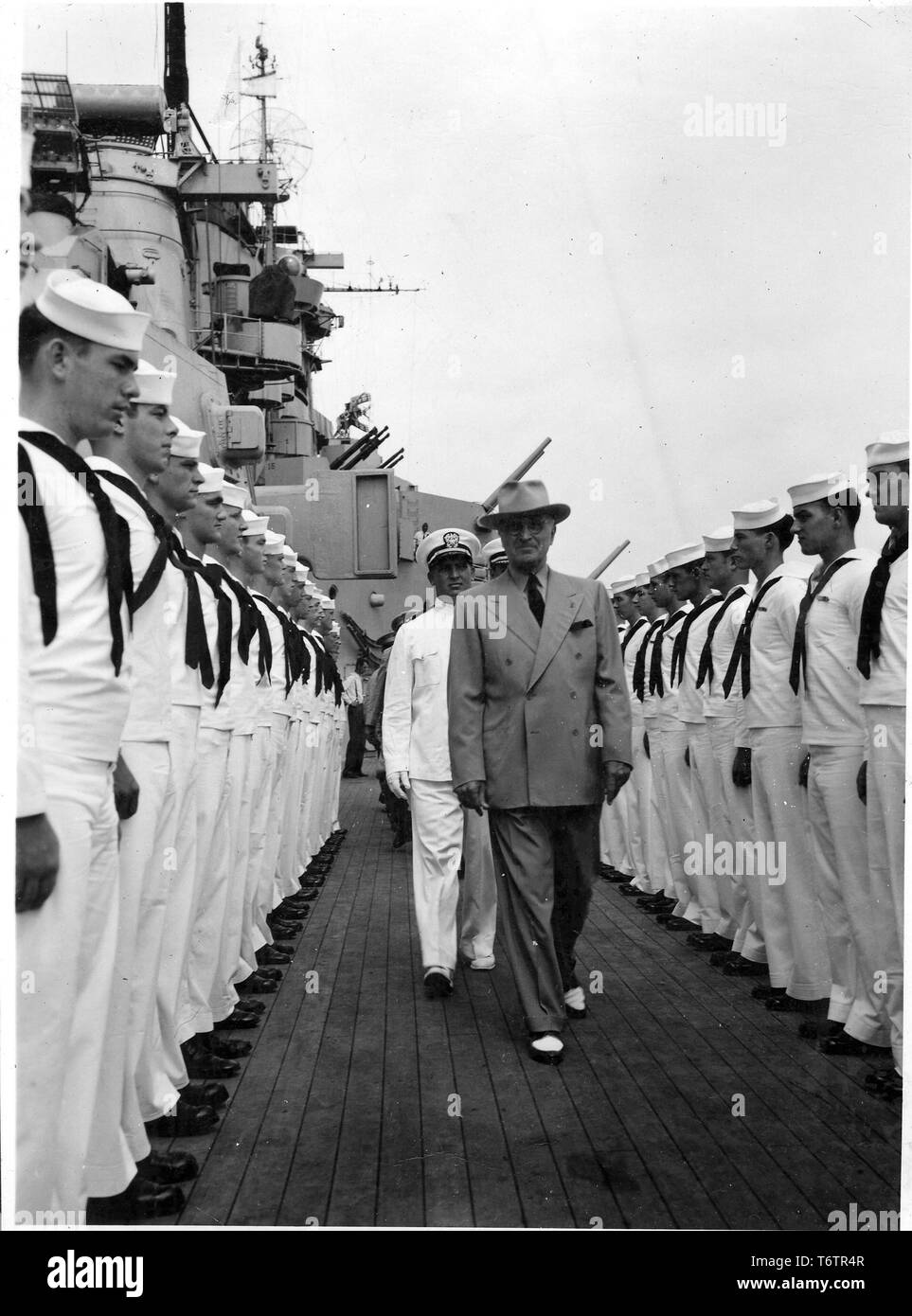 American President Harry Truman walks toward the camera, followed by Admiral James Foskett and flanked by white-uniformed Navy personnel while inspecting the USS Missouri, September 9, 1947. Image courtesy National Archives. () Stock Photo