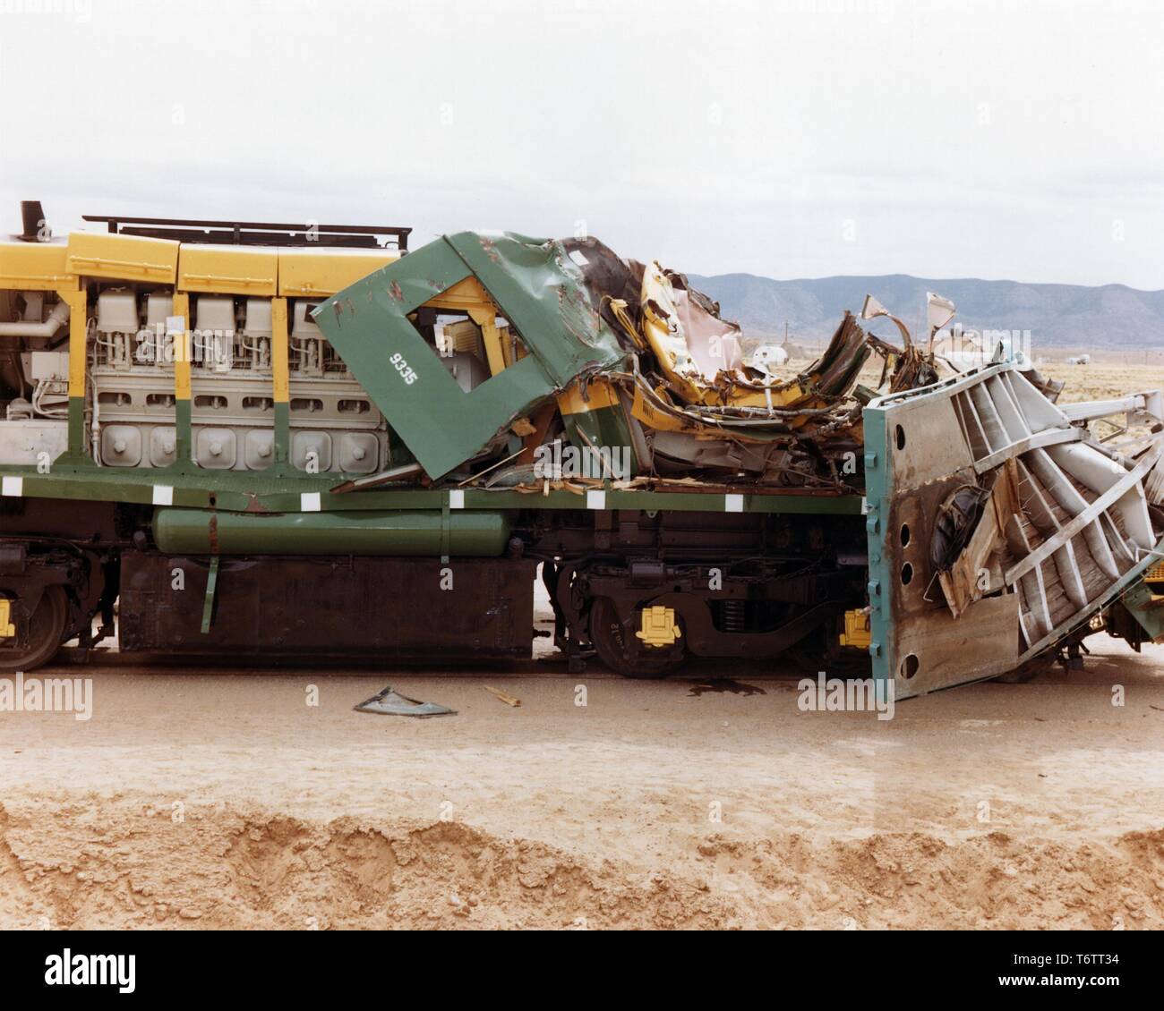 Profile view of a heavily damaged train engine after a collision with a tractor-trailer carrying a spent nuclear fuel cask during a crash test, Albuquerque, New Mexico, 1975. Image courtesy US Department of Energy. () Stock Photo