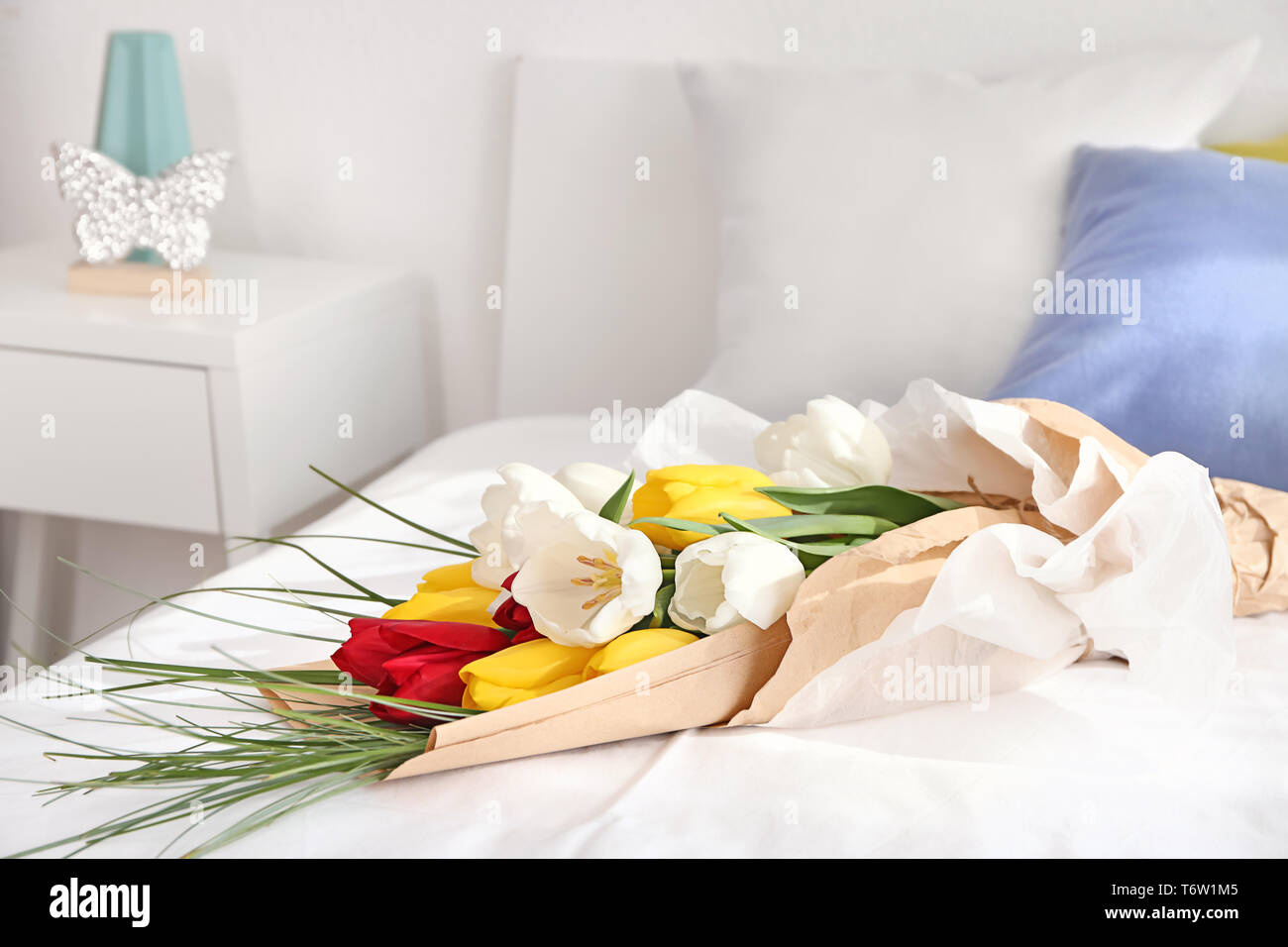 Beautiful flowers as gift on bed Stock Photo - Alamy