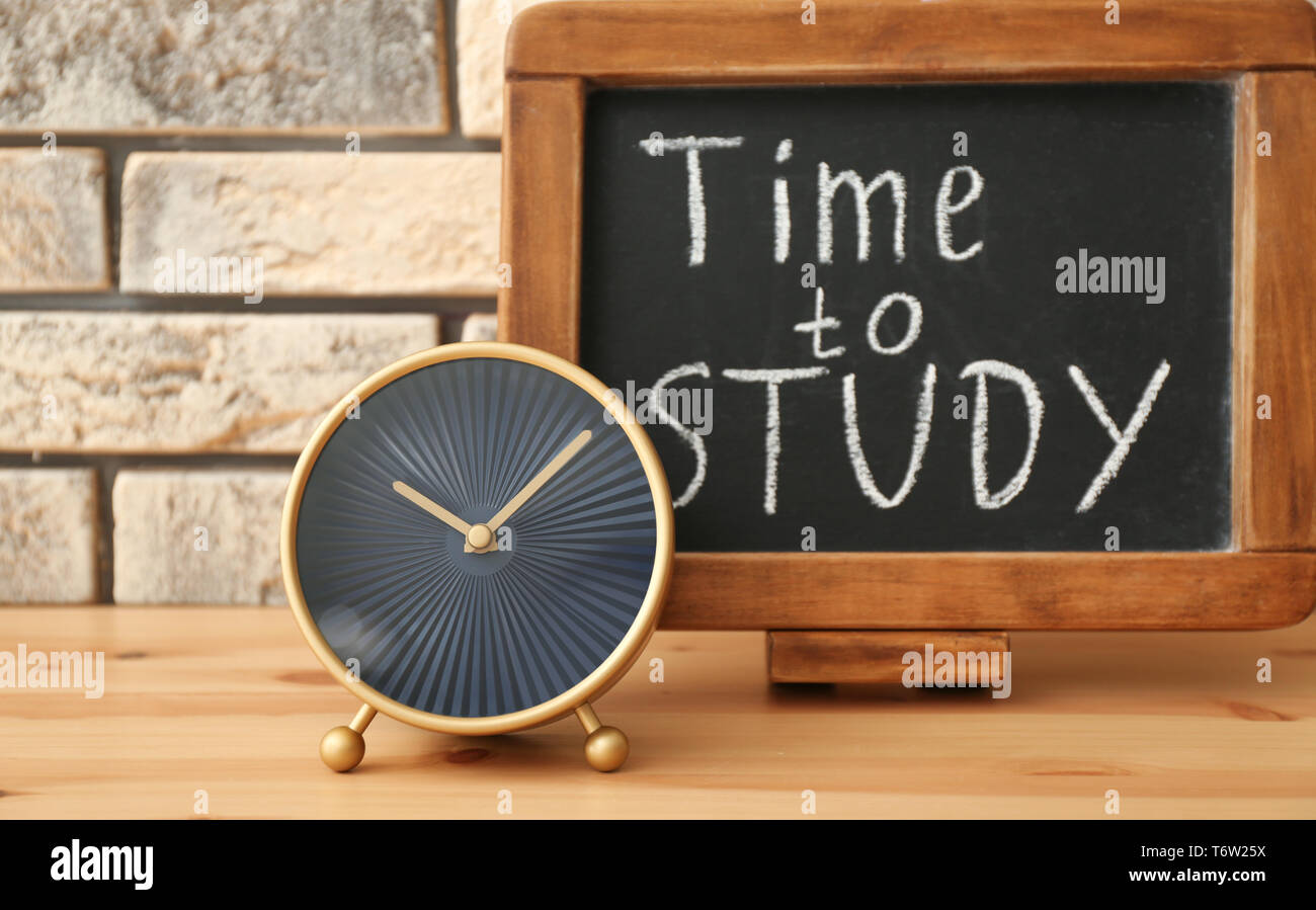 Modern clock and chalkboard with phrase 
