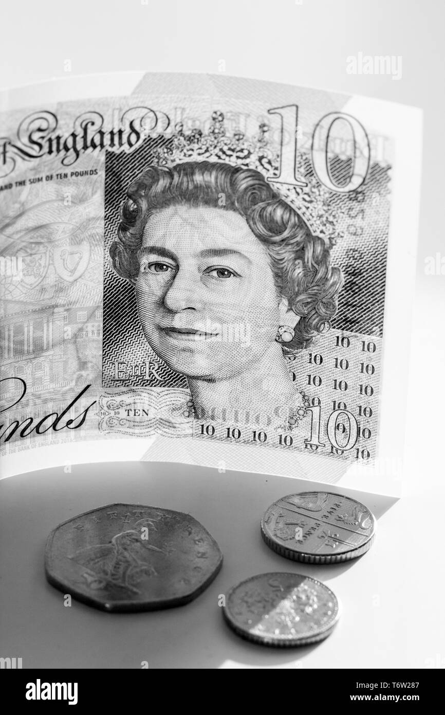 Close-up photo of a piece of new £10 banknote and pence coins. Ten pounds sterling with portrait Queen Elizabeth II Stock Photo