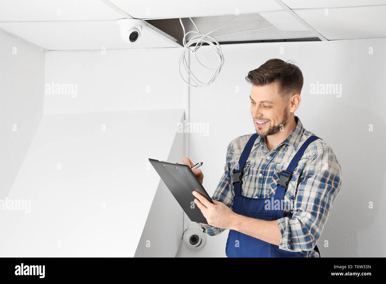 Electrician inspecting surveillance camera Stock Photo