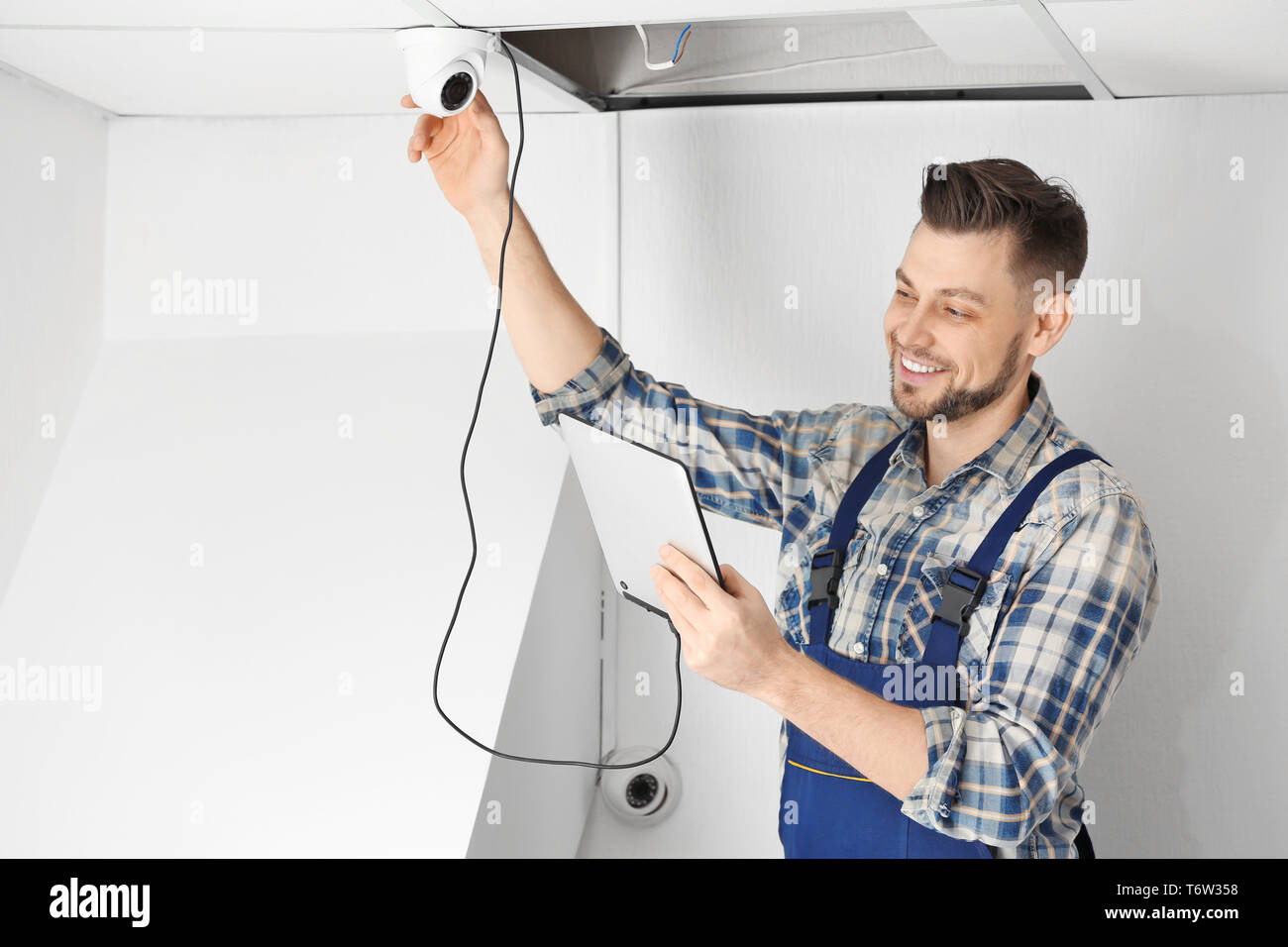 Electrician inspecting surveillance camera Stock Photo