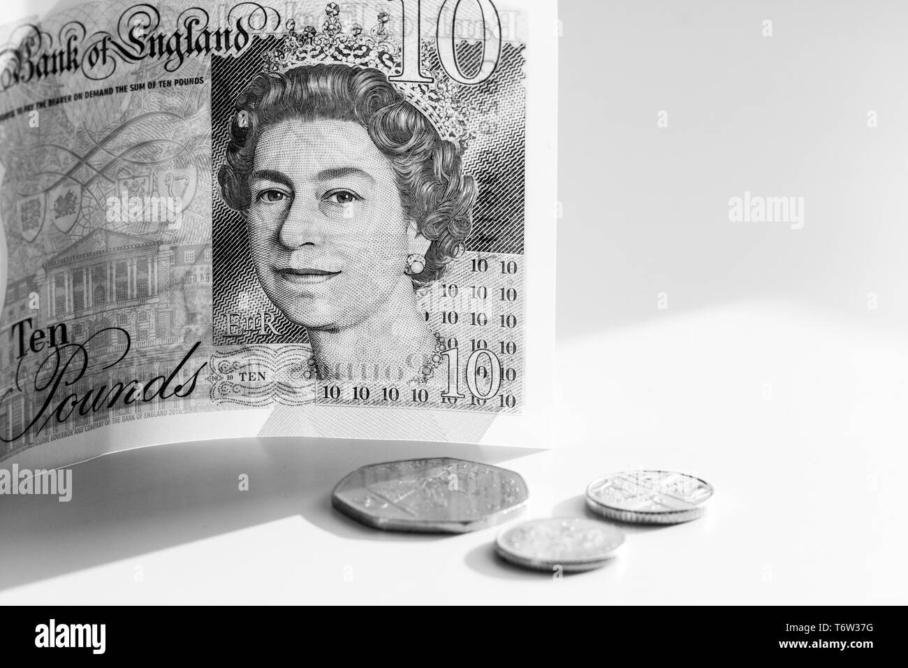 Close-up photo of a piece of new £10 banknote and pence coins. Ten pounds sterling with portrait Queen Elizabeth II Stock Photo