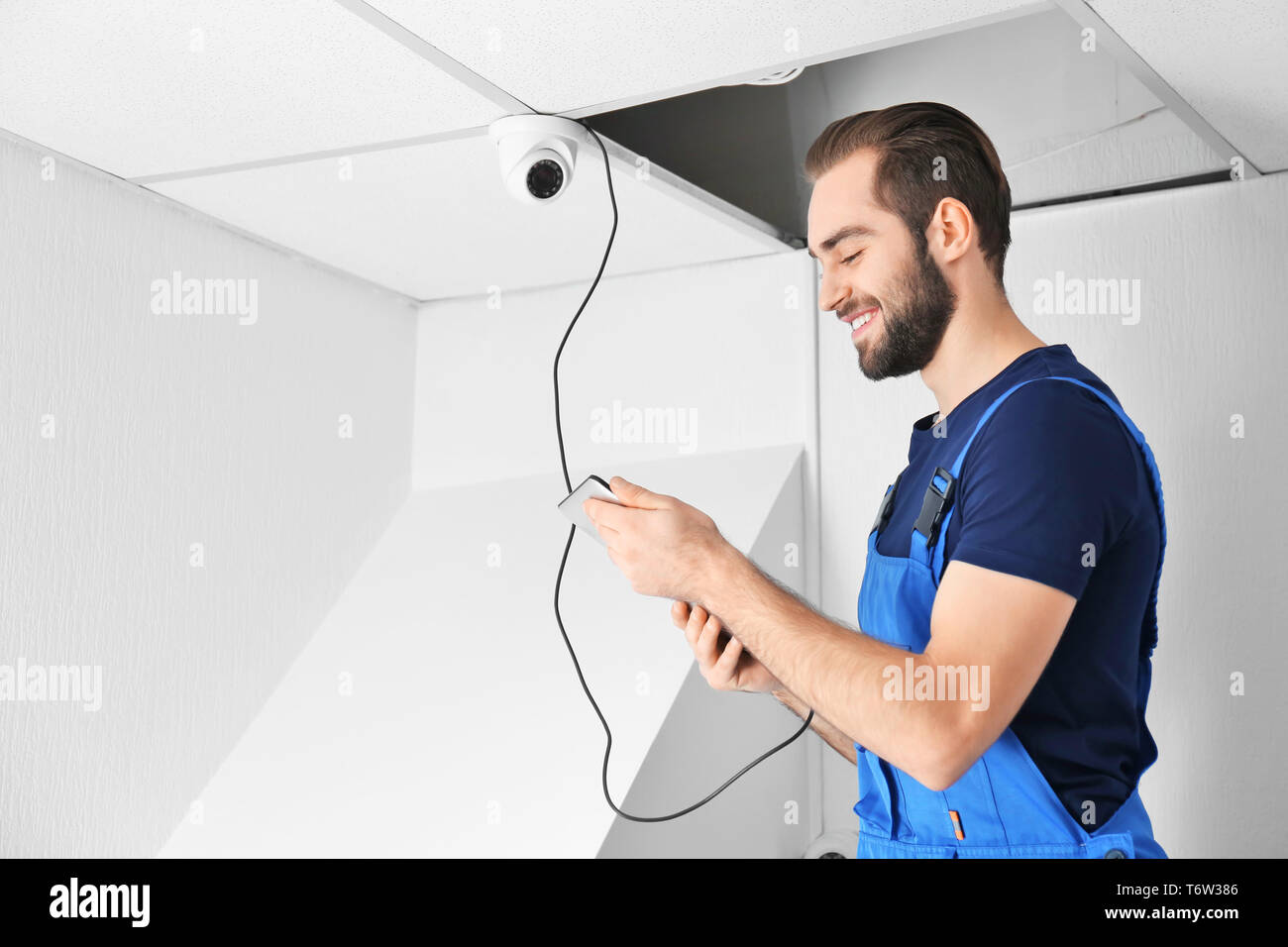 Electrician inspecting surveillance camera Stock Photo