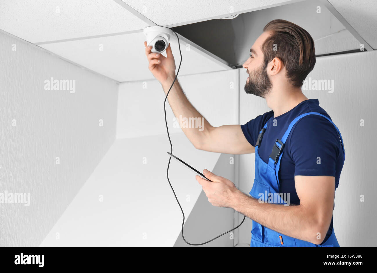 Electrician inspecting surveillance camera Stock Photo