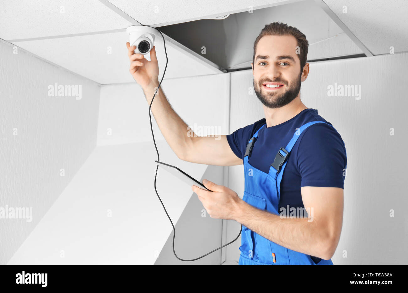 Electrician inspecting surveillance camera Stock Photo