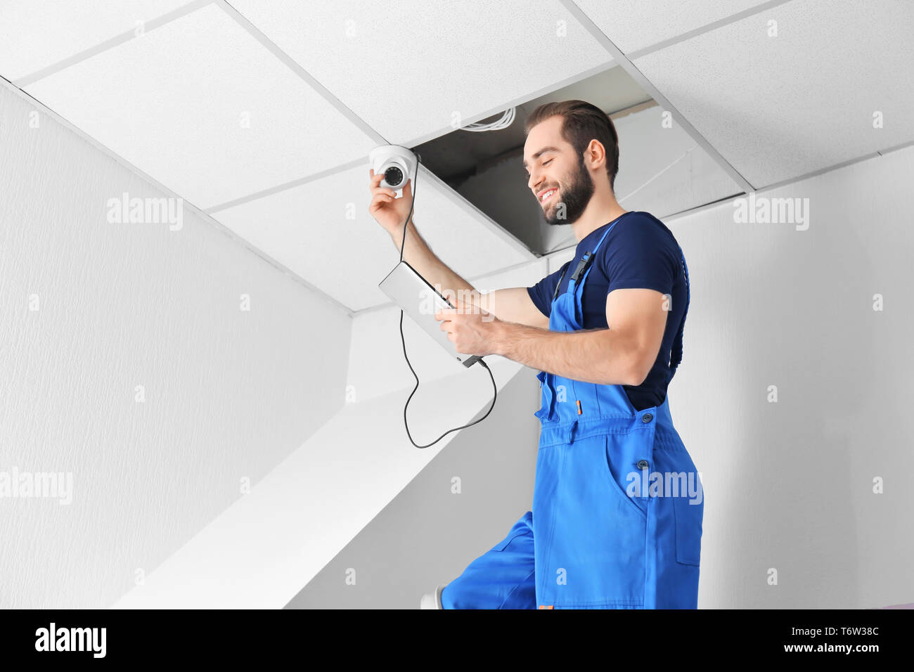 Electrician inspecting surveillance camera Stock Photo