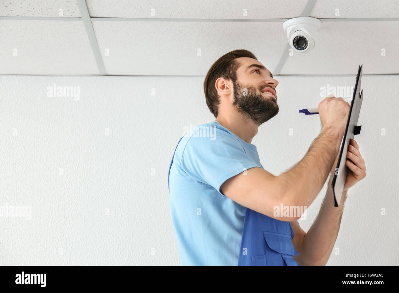 Electrician inspecting surveillance camera Stock Photo
