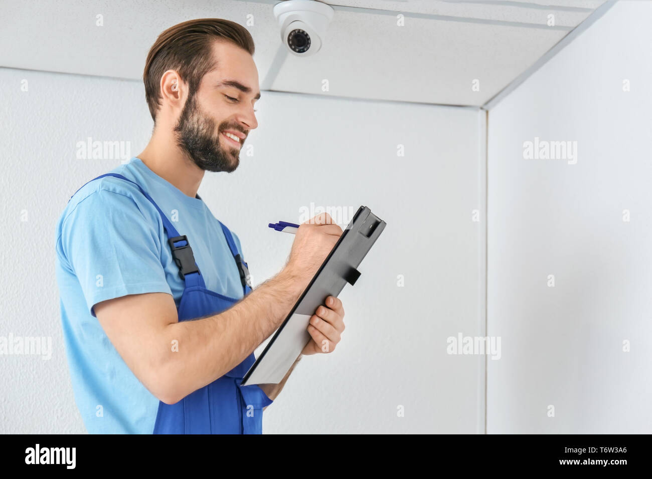Electrician inspecting surveillance camera Stock Photo