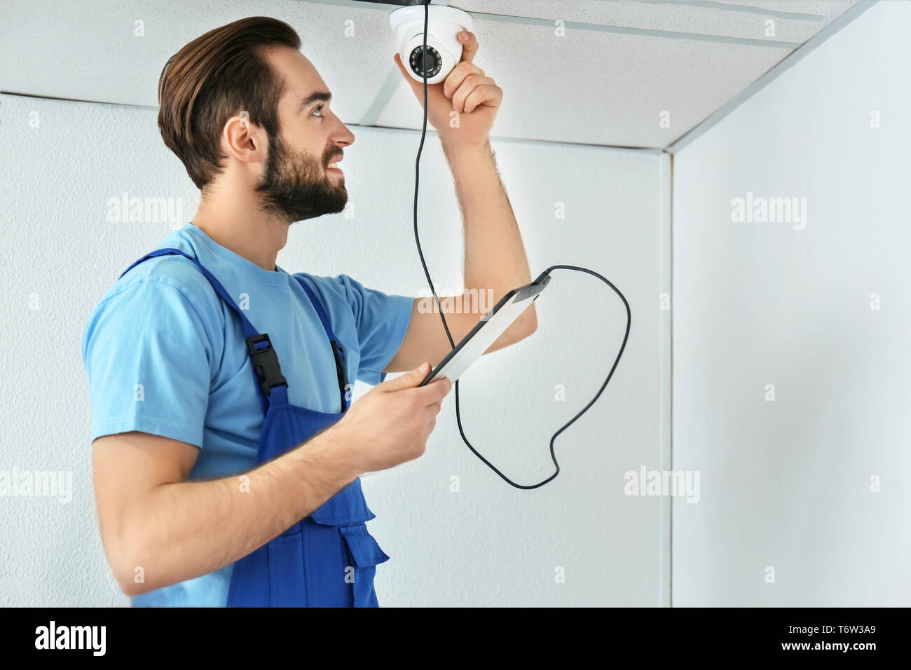 Electrician inspecting surveillance camera Stock Photo