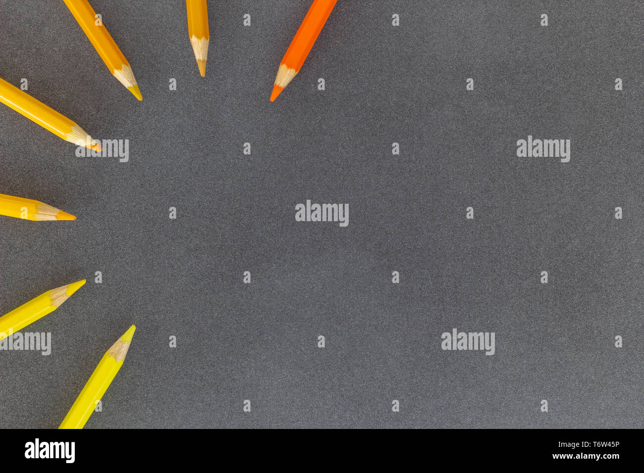 Colored pencils in semicircle close together on dark background Stock Photo