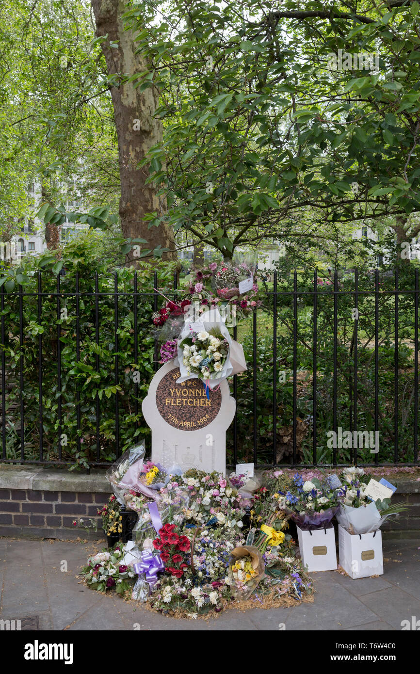 Fading flowers on the memorial to the murdered WPC Yvonne Fletcher in St. James's Square, on 29th April 2019, in London, England. WPC Yvonne Fletcher, a Metropolitan Police officer, was shot and killed by an unknown gunman on 17 April 1984, during a protest outside the Libyan embassy on St James's Square, London. Her death resulted in an eleven-day siege of the embassy, at the end of which those inside were expelled from the country and the United Kingdom severed diplomatic relations with Libya. Stock Photo