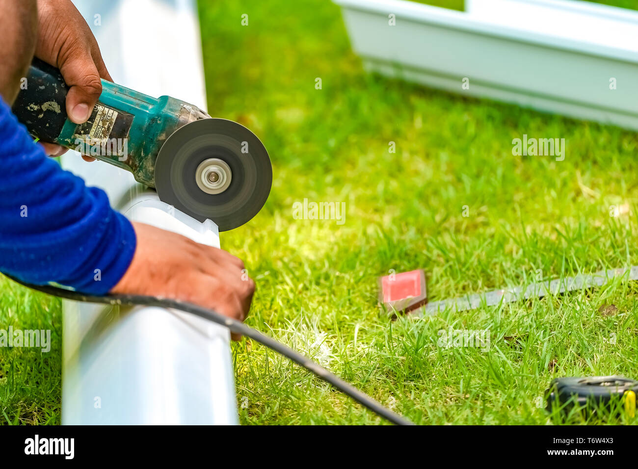 worker cutting pvc trough / spout for rooftop rainwater drain, a part