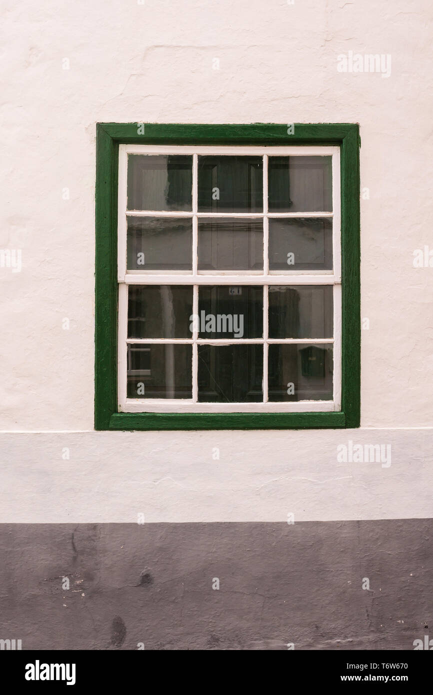 Characteristic green color of the details of the houses. White facade of a house with a window. Historical village Arico Nuevo, Tenerife, Canary Islan Stock Photo