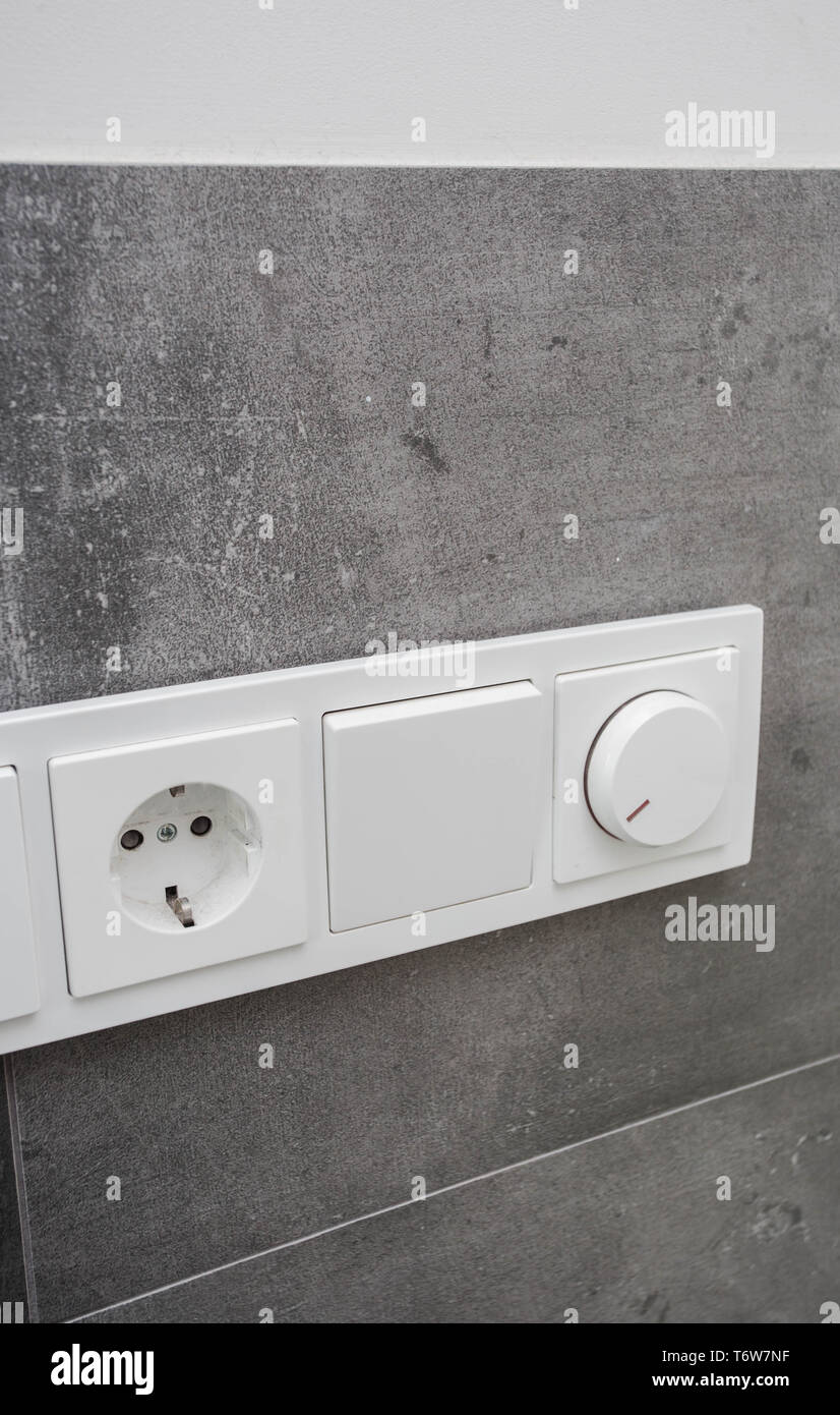 Light switch on the gray textured wall, light switch concrete wall Stock Photo