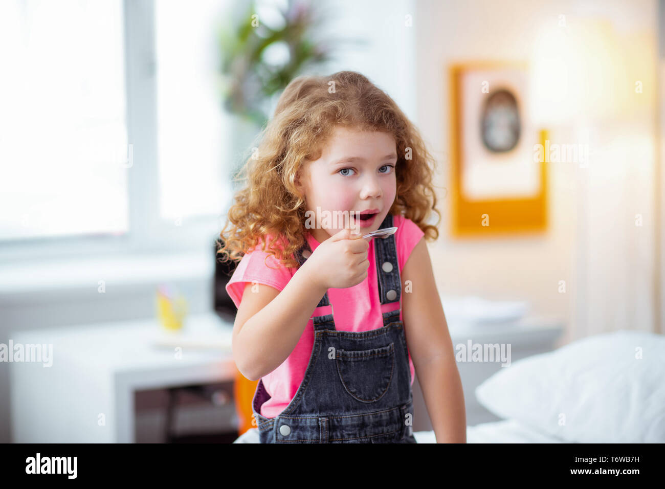 Little girl drinking cough syrup after visiting pediatrician Stock