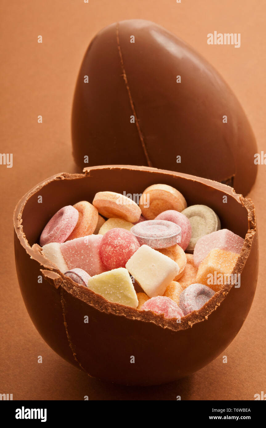 traditional Easter chocolate egg broken in half and filled with candies Stock Photo
