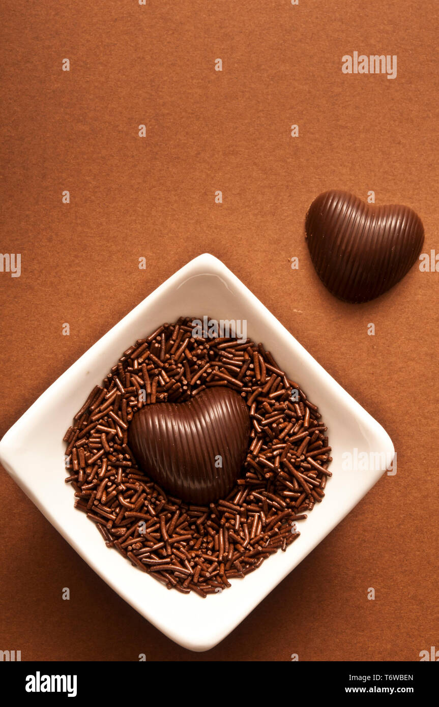 two chocolate pralines in shape of hearts Stock Photo