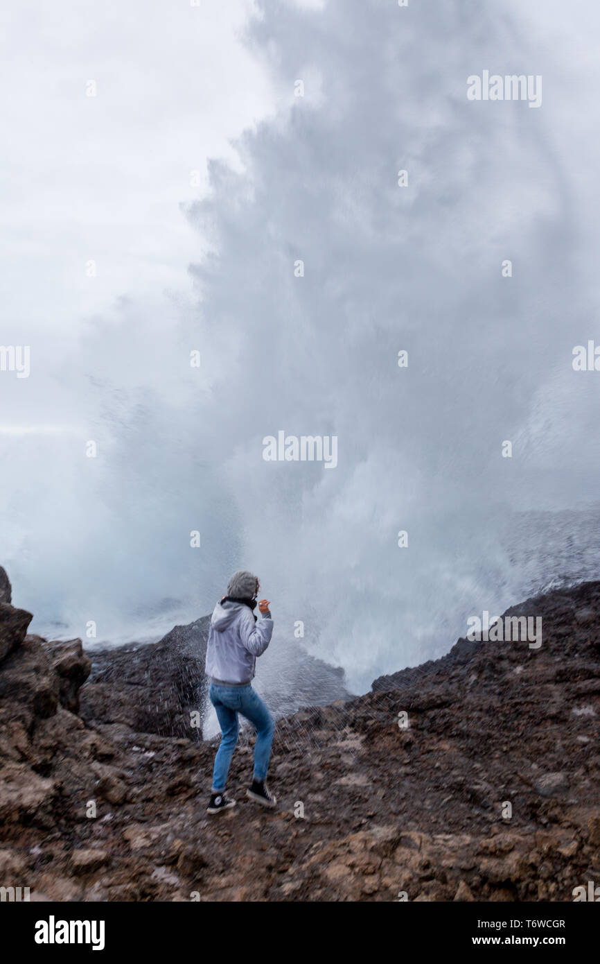 20 30 yrs old girl in front of a big water surf spray Stock Photo