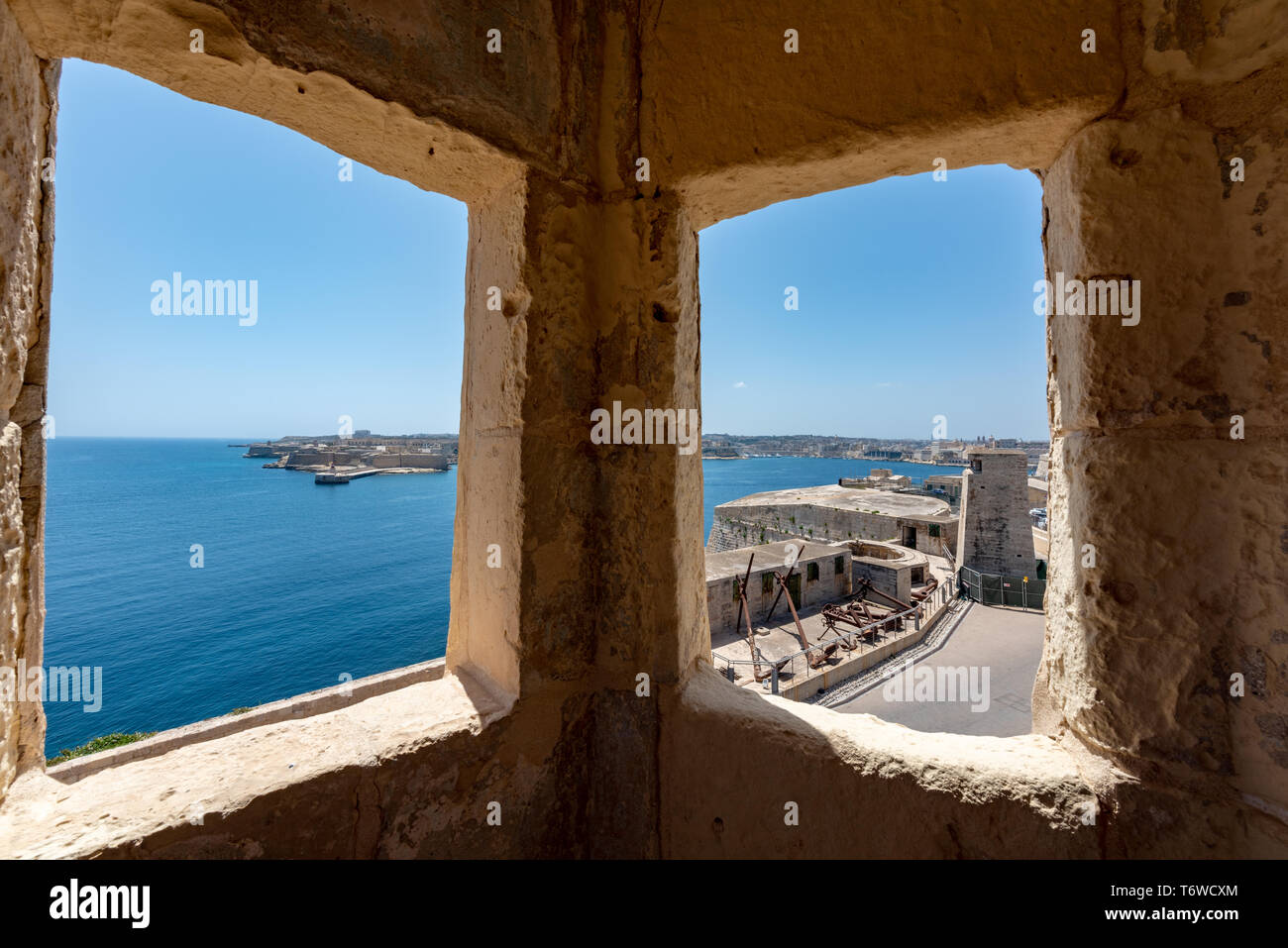 The view over Valletta's Grand Harbour from a traditional limestone watchtower on the Lazarus Bastion of Fort St Elmo Stock Photo