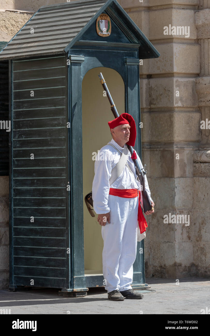 A historic re-enactment enthusiast in Napoleonic uniform stands guard at a green guard box outside the Grandmaster Palace in Republic Square, Valletta Stock Photo