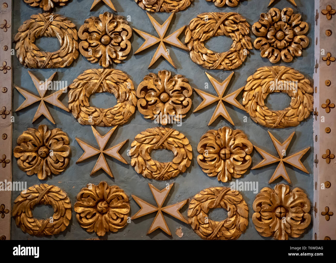 Detail of the gilded motifs of garlands and Maltese crosses carved into the soft Maltese Limestone in St John's Co-Cathedral, Valletta. Stock Photo