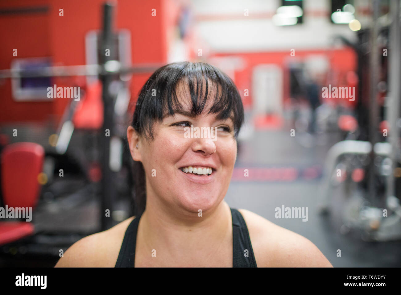 Portrait of woman smiling at gym during workout. Stock Photo