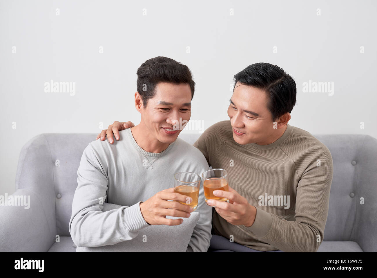 Men talk concept. Two young male friend gathering, chatting and eating at home. Stock Photo