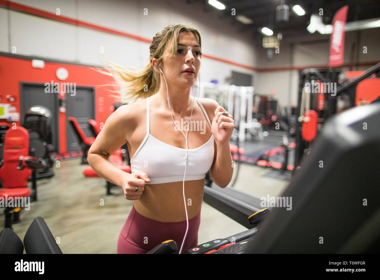 Young confident woman running on a treadmill Stock Photo
