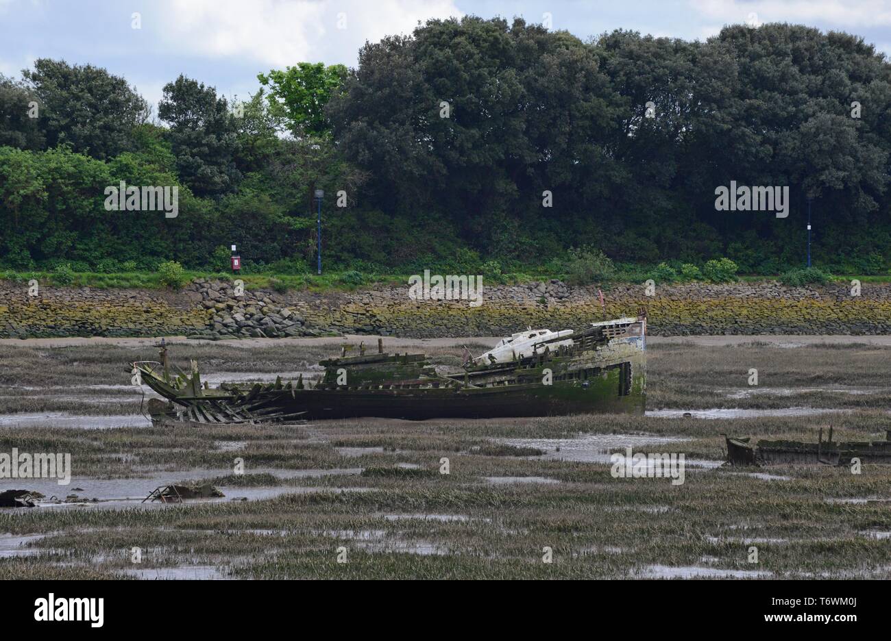 Rotting hulk of abandoned ship in the mudflats at Barry Island, South Wales Stock Photo