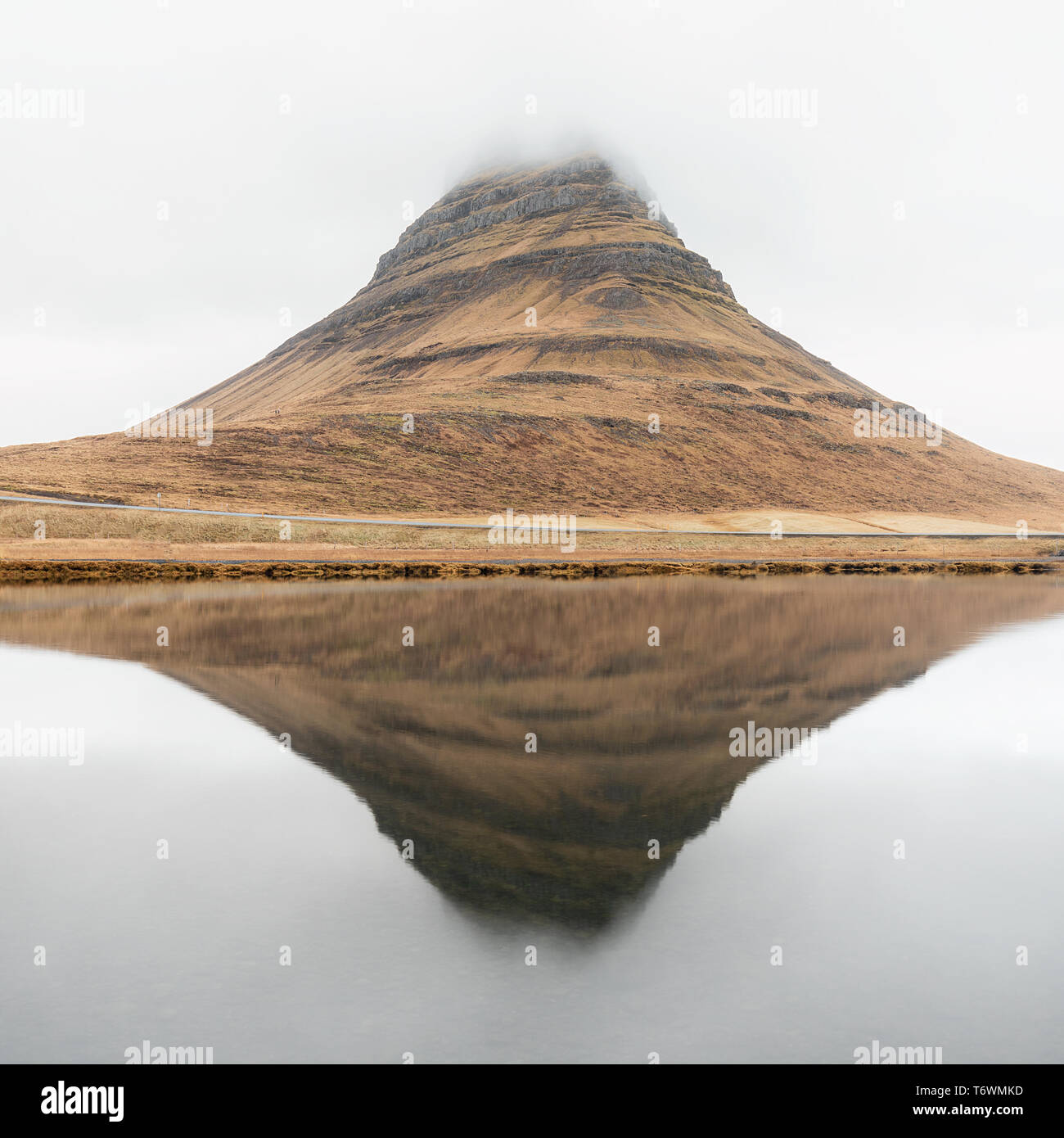 Kirkjufell mountain under the clouds reflection in the water Stock Photo
