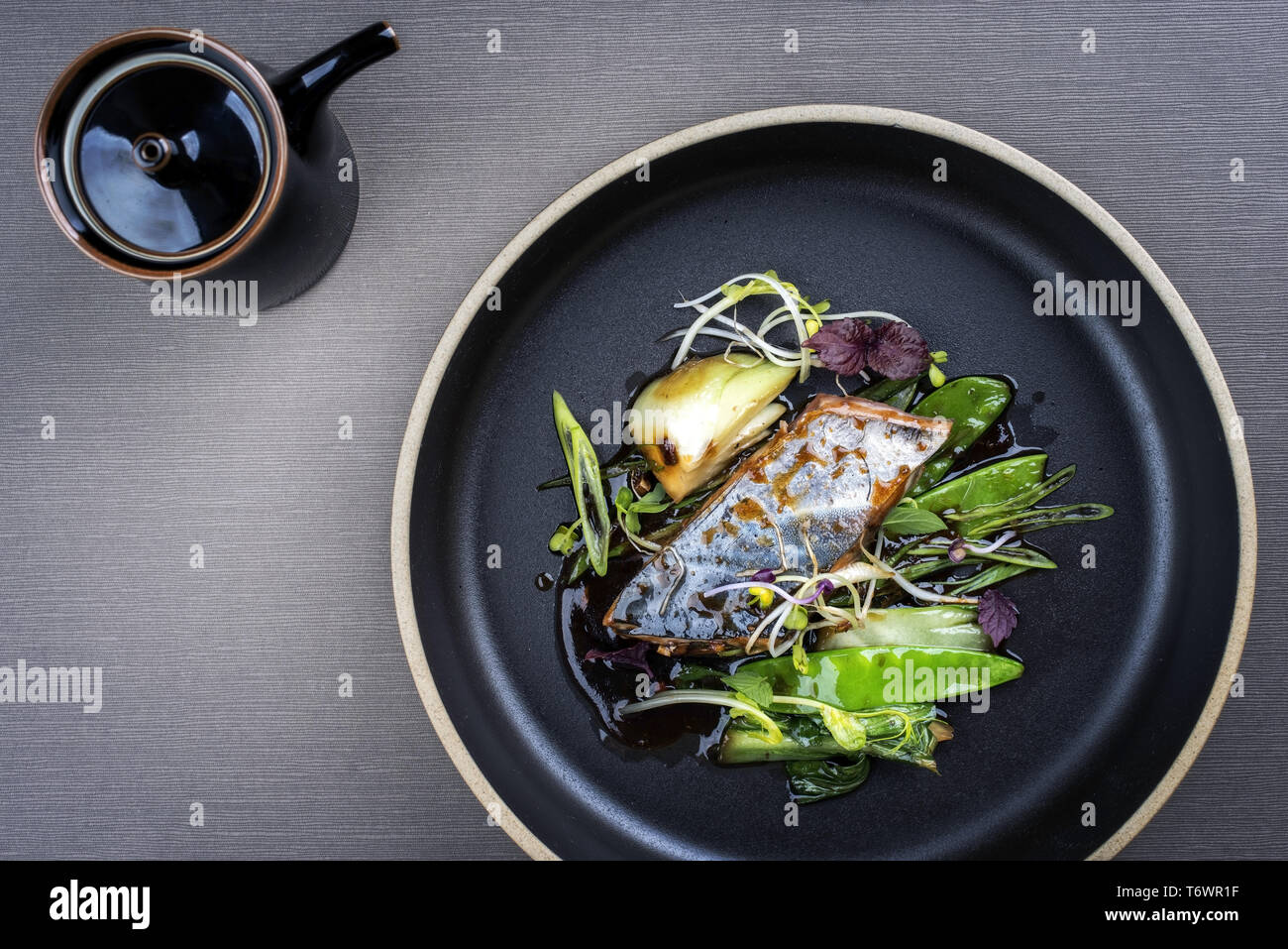Modern style Japanese bonito tuna fish filet with vegetable glazed in teriyaki sauce as top view on a plate with copy space Stock Photo