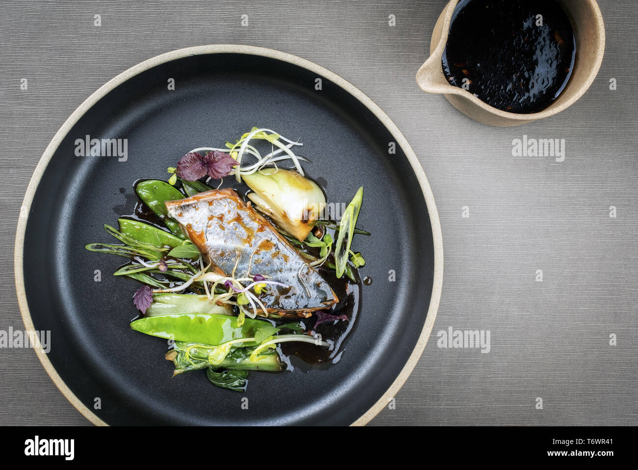 Modern style Japanese bonito tuna fish filet with vegetable glazed in teriyaki sauce as top view on a plate with copy space Stock Photo