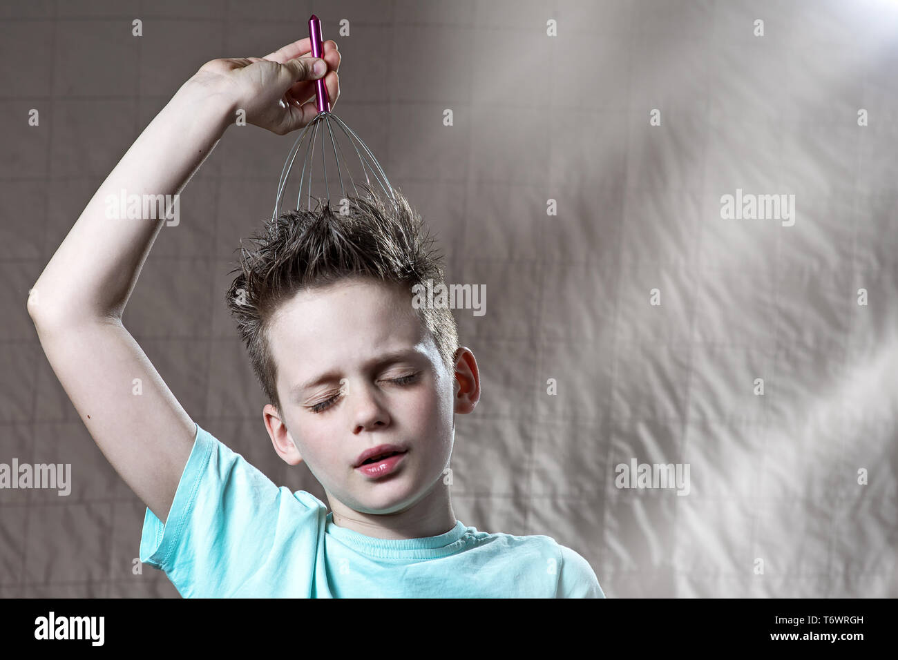 the boy tickles his head with a scratcher and covered his eyes with