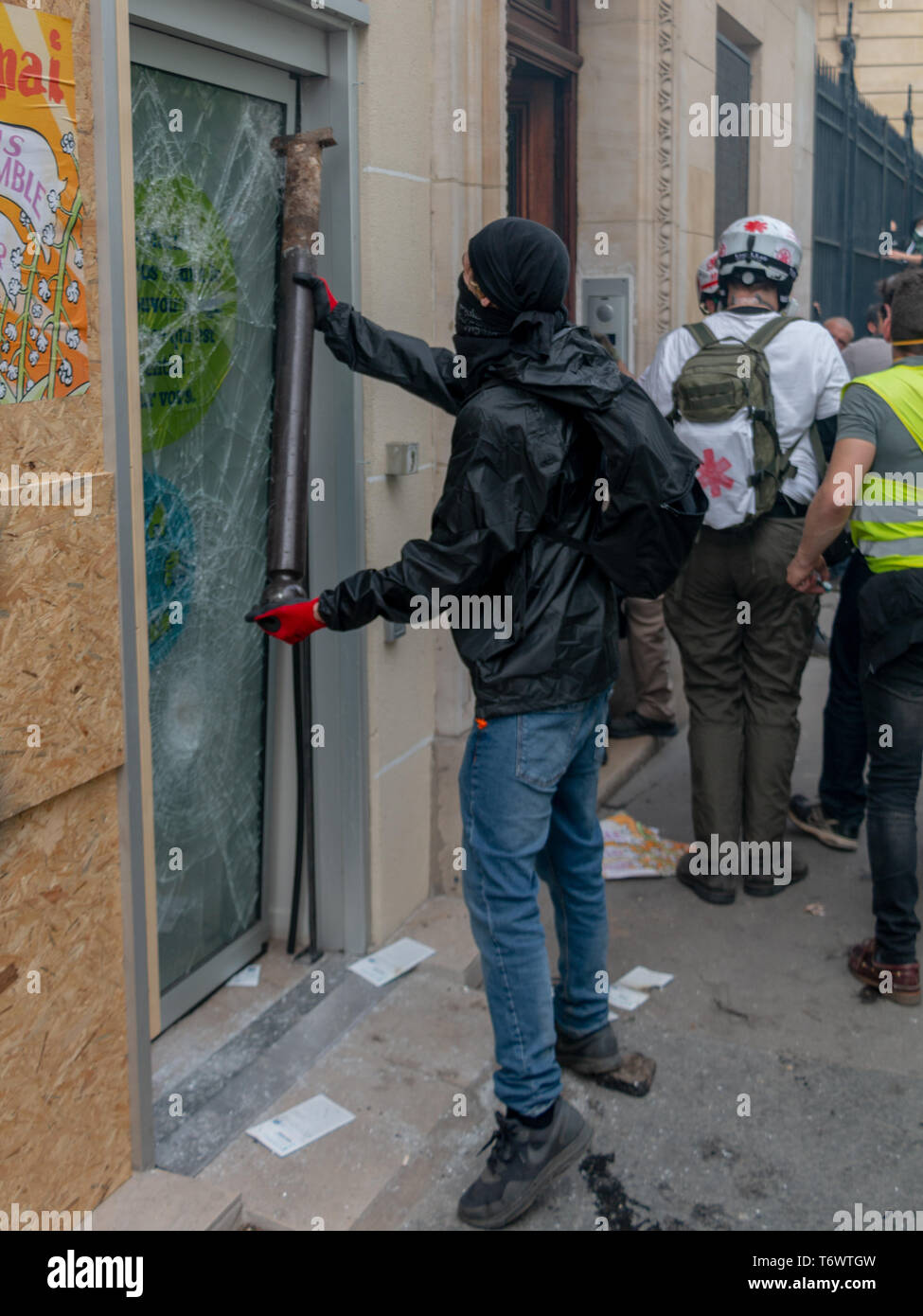 Un black bloc casse la porte d'une agence d'assurance à Paris, pendant la fête du travail (1er Mai 2019) Stock Photo